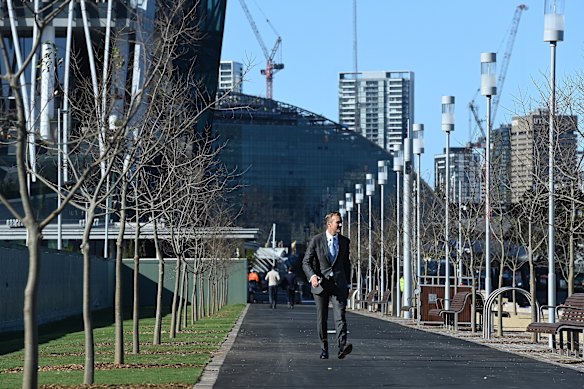 Planning and Public Spaces Minister Rob Stokes paces the tree-lined walkway at Barangaroo.