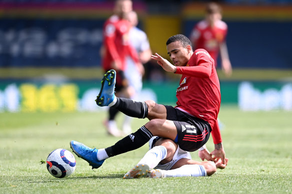 Manchester United’s Mason Greenwood is tackled by Tyler Roberts of Leeds United.