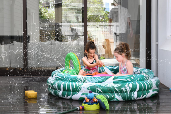 Florence and Grace Scotting cool off in their paddling pool at Balmain on the second day of a record breaking November heatwave. 