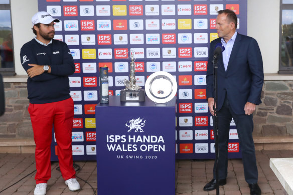 Former Australian PM Tony Abbott, right, presents the Wales Open trophy to Romain Langasque, of France, at the Celtic Manor Resort in Newport, Wales.