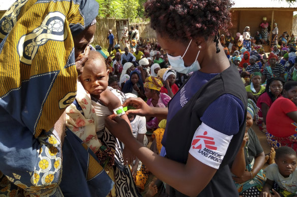 An MSF (Doctors Without Borders) staff member checks a child for malnutrition in Meluco, in the northern Mozambican province of Cabo Delgado, February 19, 2021.