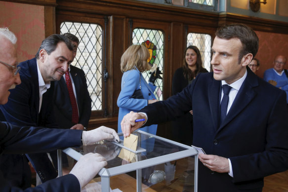 French President Emmanuel Macron casts his ballot in the mayoral elections on Sunday.