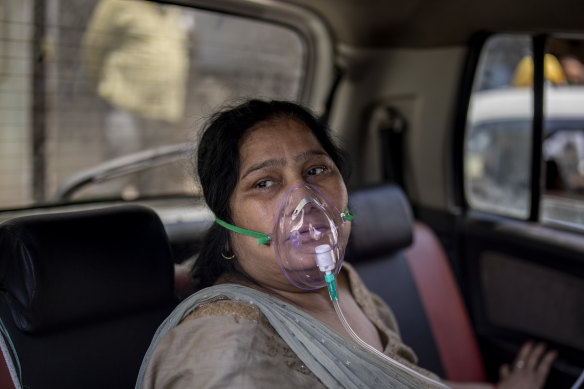 A COVID-19 patient sits inside a car and breathes with the help of oxygen provided by a Gurdwara, a Sikh house of worship, in Delhi, India.