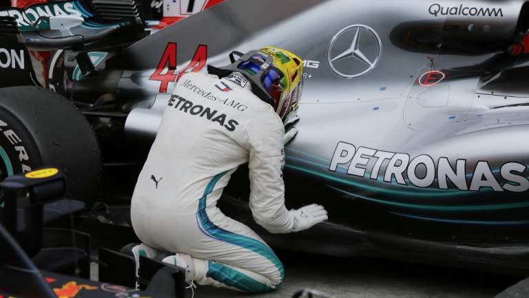 Higher power: Mercedes driver Lewis Hamilton kneels next to his car after winning the Brazilian GP.