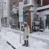 Emma Pidden waits for her bus on Congress Street in Portland, Maine following a spring snowstorm.