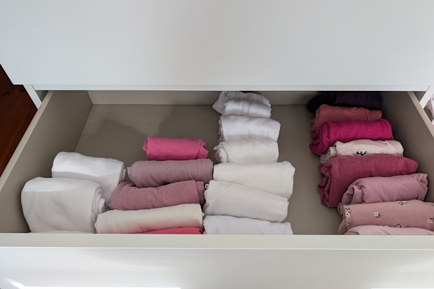 Clothes drawer with neatly folded shirts using Marie Kondo's file folding method.