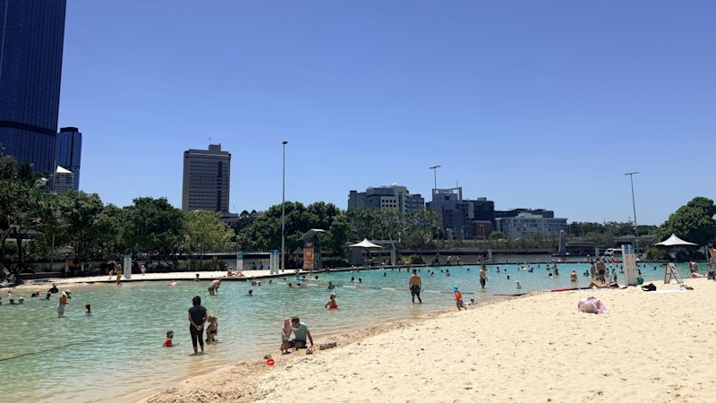 Brisbane swelters through hottest Australia Day in 27 years, as storm hits nearby region