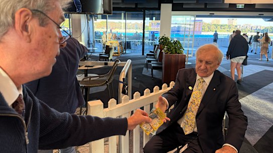 Bookmaker Robbie Waterhouse hands over the election bet cash to former Labor minister John Brown.