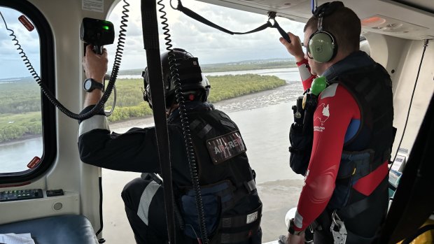 An emergency crew helps rescue a man from deep mud in Moreton Bay.