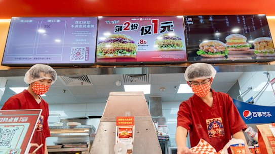 Fast food workers at Chinese burger chain Tastien prepare orders at a store in Beijing.