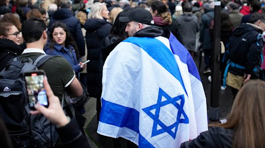 A demonstrator wearing in Israeli flag joins thousands other people for a march against antisemitism in Paris, France, Sunday, Nov. 12, 2023. French authorities have registered more than 1,000 acts against Jews around the country in a month since the conflict in the Middle East began.