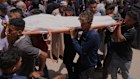Palestinians carry the body of a person killed while heading to a Gaza aid hub in Khan Younis.