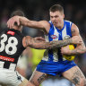 North Melbourne’s Cameron Zurhaar attempts to break a tackle by Collingwood’s Jeremy Howe.