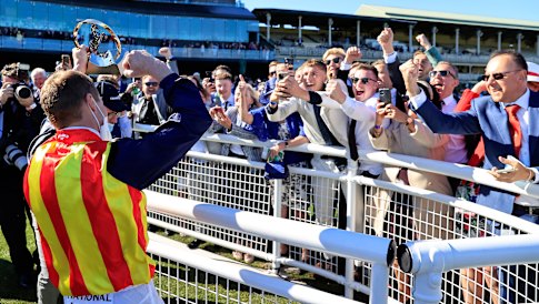 James McDonald shows off his trophy for The Everest to the crowd at Randwick on Saturday
