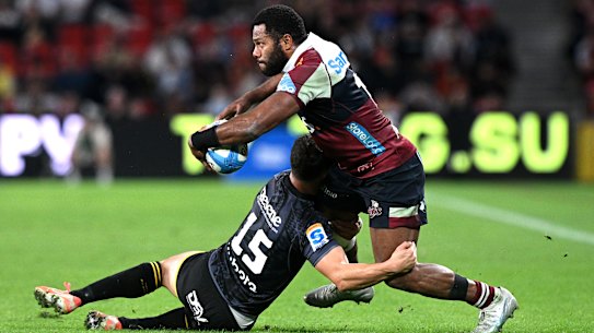 Filipo Daugunu of the Reds is tackled by Callum Harkin of the Hurricanes.