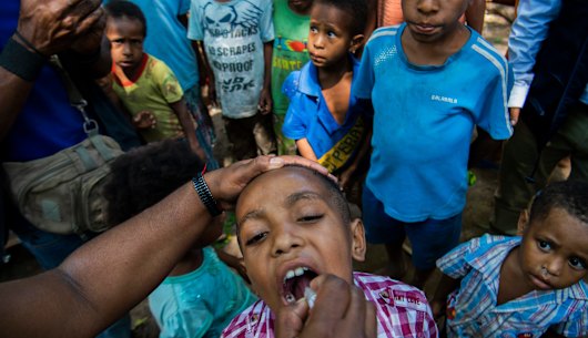 A child in Papua New Guinea receives a polio vaccine. The coronavirus outbreak threatens to reverse decades of progress in alleviating poverty.