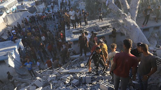 Palestinians search for bodies and survivors in the rubble of a residential building destroyed in an Israeli airstrike in Khan Younis.