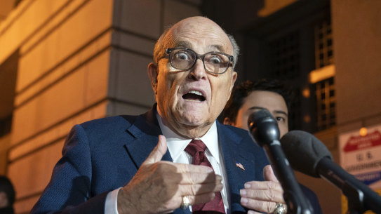Former New York mayor Rudy Giuliani talks to reporters outside court in Washington. The trial will determine how much he pays in damage to two defamed Georgia election workers.