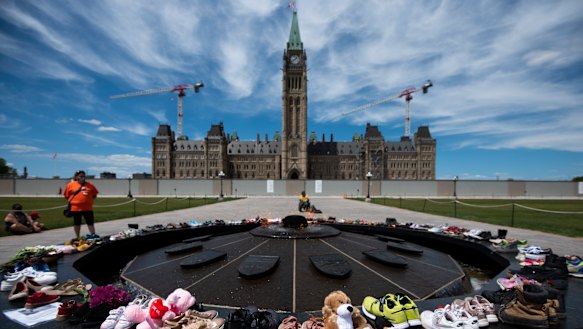 Shoes line the edge of the Centennial Flame on Parliament Hill in memory of the 215 children whose remains were found.