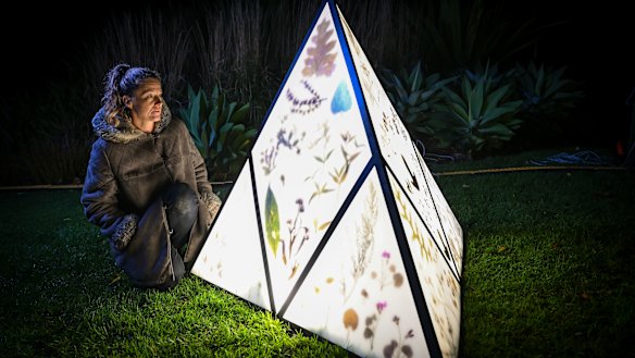 Melbourne artist Kathy Holowko in front of her one of her lanterns showcasing the work of the herbarium. 