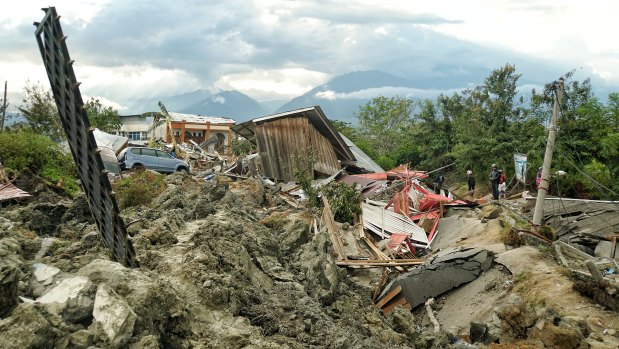 A man looks at the mud chaos left by the broken water embankment in Petobo, a district of Palu. 