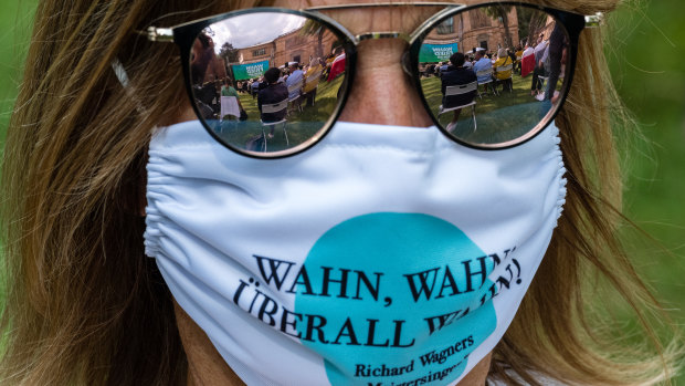 A spectator with a face mask arrives for the opening of the Bayreuth Festival in Germany.