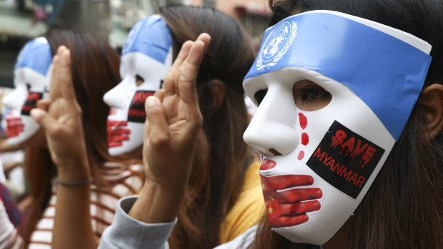Young demonstrators wear masks to protest China’s blocking of sanctions at the United Nations security council.