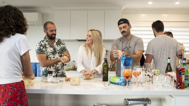 Alessandro Badalamenti shows his friends Caroline Heslop and Alex Colvin how to make pasta in Mosman.