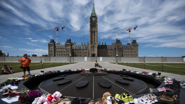 Shoes line the edge of the Centennial Flame on Parliament Hill in memory of the 215 children whose remains were found.