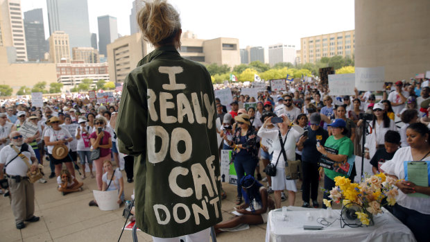 Actress and activist Cheryl Allison wears a "I Really DO Care, Don't U" green jacket as she speaks during the Keep Families Together rally at Dallas City Hall  on Saturday.