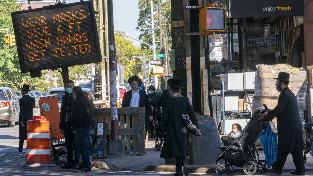 A traffic sign asks people to keep socially distant on New Utrecht Avenue in the Orthodox Jewish neighbourhood of Borough Park in Brooklyn.