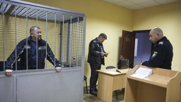 Oleg Smorodinov in a defendant’s cage in a courtroom in Rivne.