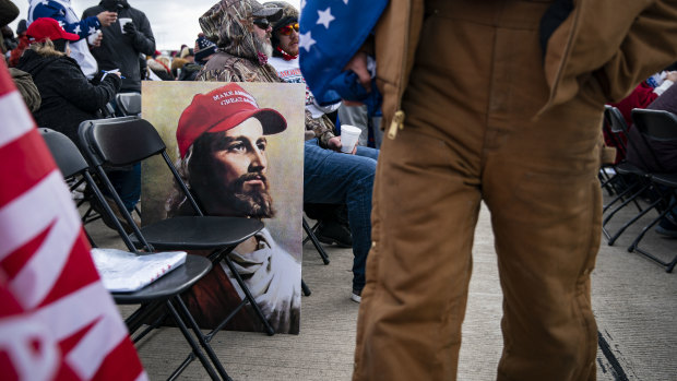 An attendee walks past a poster of Jesus wearing a "Make America Great Again" hat ahead of campaign rally for US President Donald Trump in Scranton, Pennsylvania.