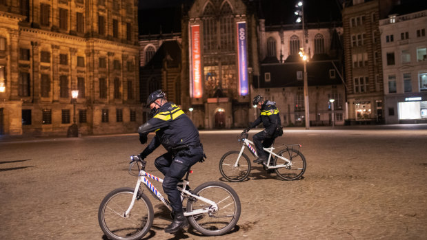 Police officers patrol a street in Amsterdam, Netherlands, where an emergency nighttime curfew has been introduced for the first time since World War II. 