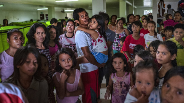 Evacuees queue to receive relief goods at an evacuation center during the onslaught of Typhoon Kammuri, in Batangas, Philippines.