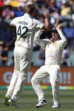 Cameron Green and Steve Smith celebrate the wicket of England captain Joe Root.