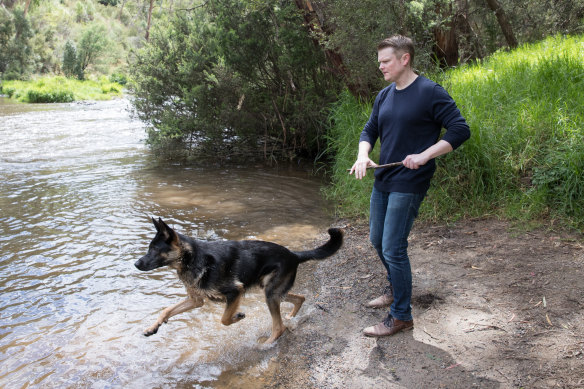 Keith Wolahan plays with his dog Jet at the river in Warrandyte