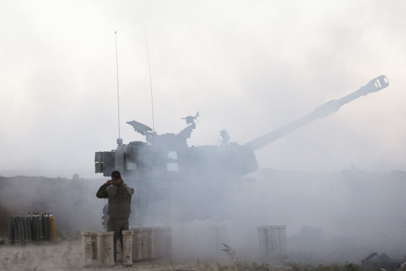 An Israeli soldier operates an artillery unit as it fires near the border between Israel and the Gaza Strip on May 18, 2021 in Sderot, Israel. 