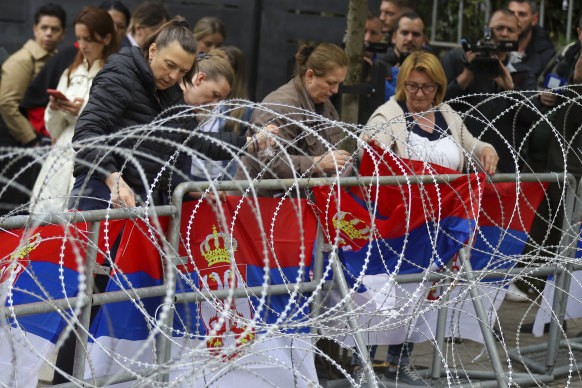 Women attach Serbian flags to a fence in front of the city hall during a protest in the town of Zvecan, northern Kosovo earlier this year.