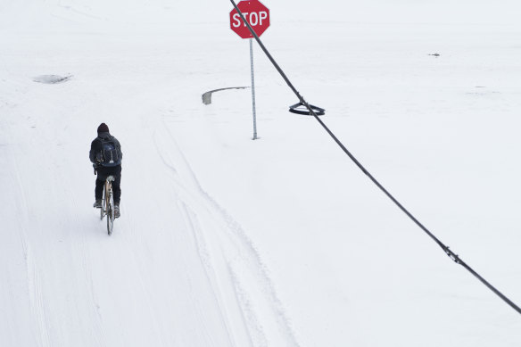 A person rides a bicycle through snow in McKinney, Texas.