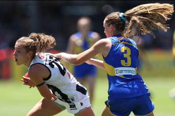 Mikala Cann of the Magpies looks to break from a tackle by Charlotte Thomas.