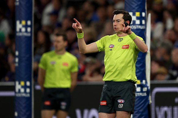 Field umpire Andrew Stephens signals for a goal review last season.
