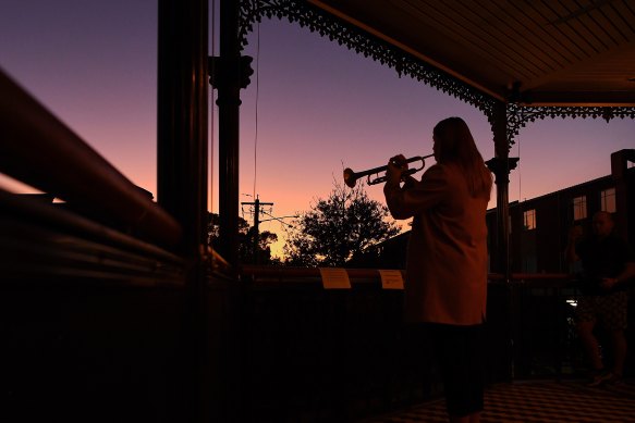 Bugler Sarah Brown, 23, plays The Last Post from the balcony of The Royal Hotel in Leichhardt on April 25, 2020. 