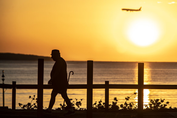 An early morning walker exercises in Brighton-le-Sands ahead of a sweltering January summer day.