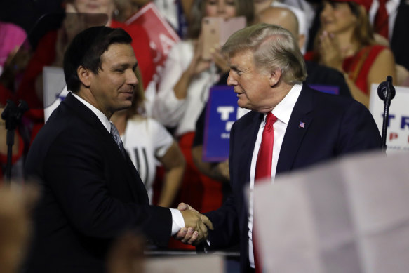 Then president Donald Trump, right, shakes hands with Florida Republican governor candidate Ron DeSantis during a rally in Tampa in 2018.