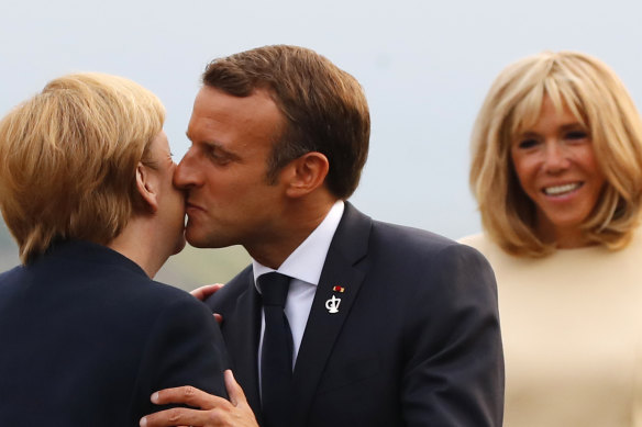 Kiss it good-bye, say some French.
French President Emmanuel Macron, kisses German Chancellor Angela Merkel, while his wife Brigitte looks on in 2019.