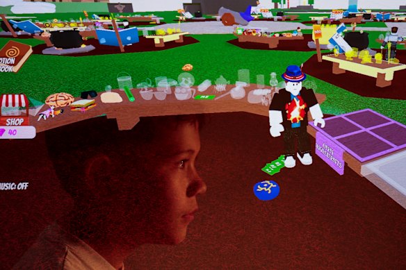In a multiple exposure image, a 10-year-old Sydney boy looks at a game hosted on the Roblox platform.
