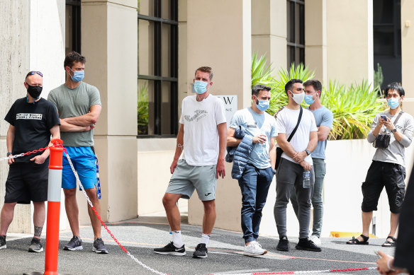 People associated with the Australian Open are seen lining up at a testing facility 
