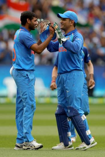 Bhuvneshwar Kumar of India celebrates catching Glenn Maxwell of Australia with MS Dhoni 