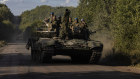 Ukrainian troops ride on top of a tank near the Russian border in the Sumy region.